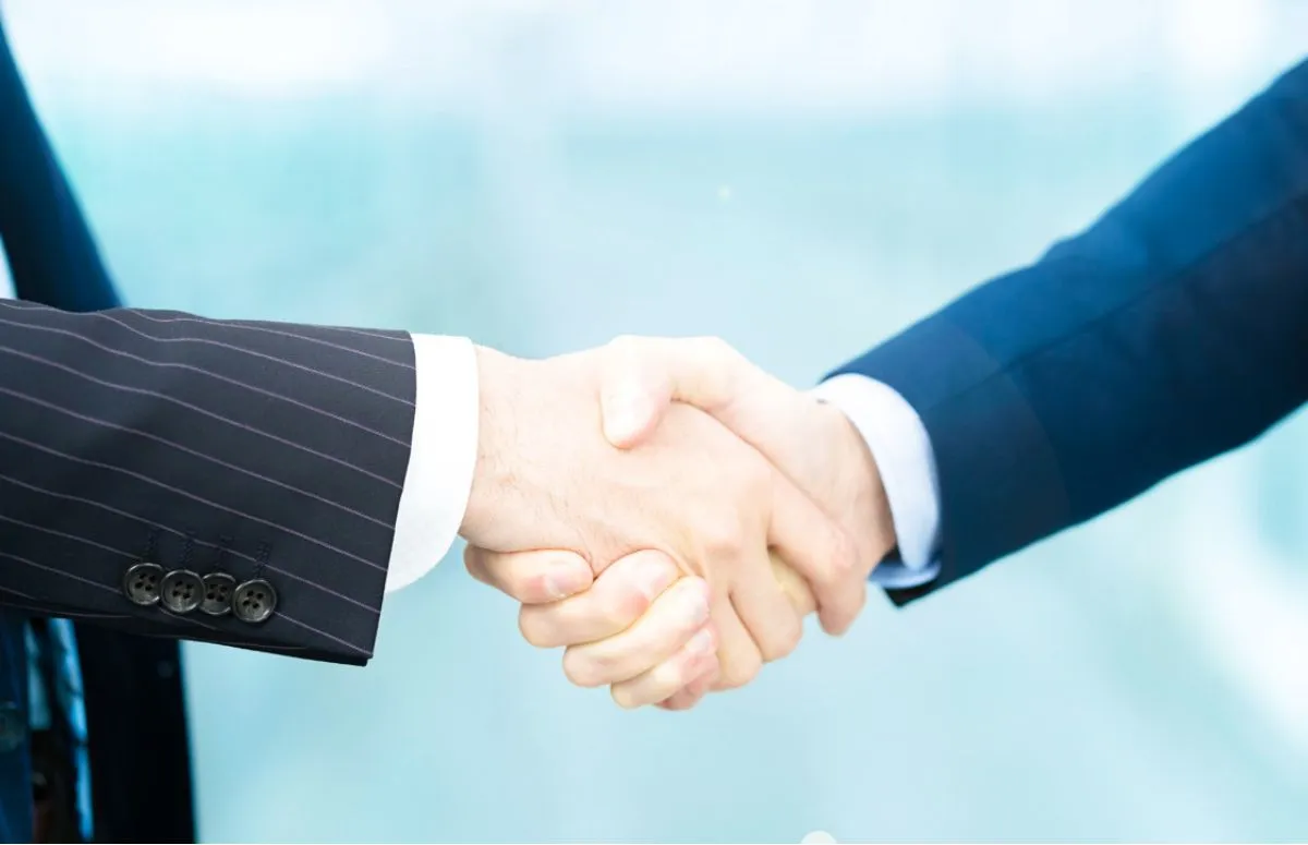 ビジネスマンが取引先と握手する写真